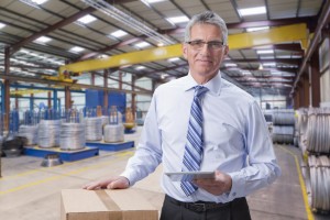 Portrait of smiling supervisor holding digital tablet in warehouse